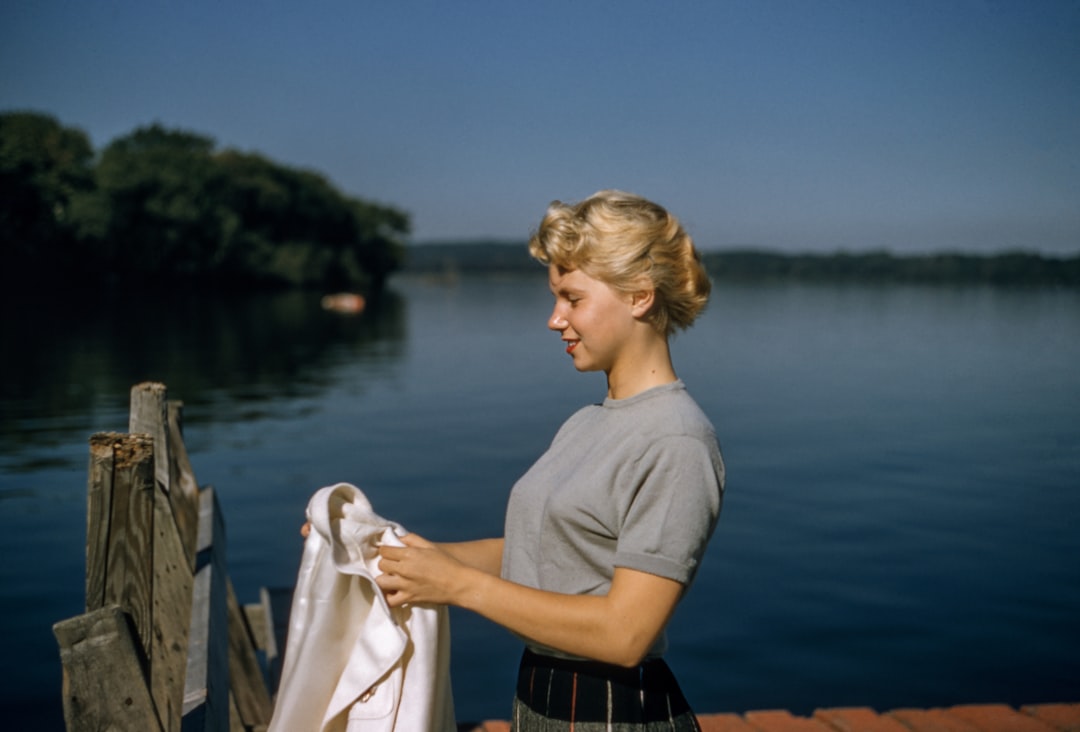 Vintage Hair by Bike Brands woman holding white textile standing beside body of water