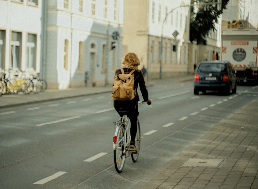 FAQ: Your Burning Questions About Belgian Road Bikes Answered by Bike Brands woman in black jacket riding bicycle on road during daytime