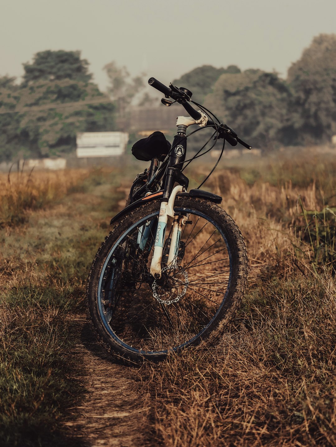 a bicycle parked on a dirt road